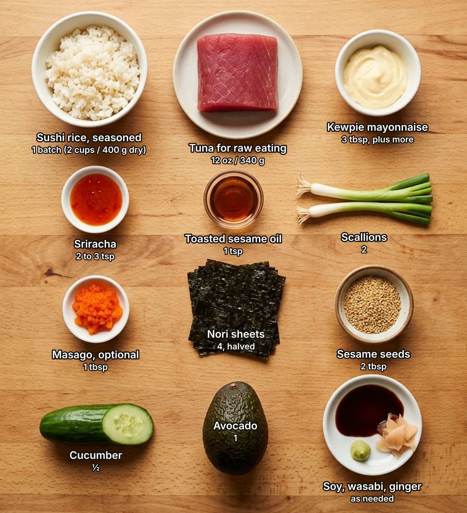 Spicy tuna roll ingredients laid out overhead on a wooden counter and labelled with quantities: a bowl of seasoned sushi rice, a raw block of tuna on a plate and a bowl of Kewpie mayonnaise across the top; dishes of sriracha and toasted sesame oil beside two scallions in the second row; a dish of masago, a stack of nori sheets and a bowl of sesame seeds in the third row; half a cucumber, a whole avocado, and a saucer of soy sauce with wasabi and pickled ginger below.